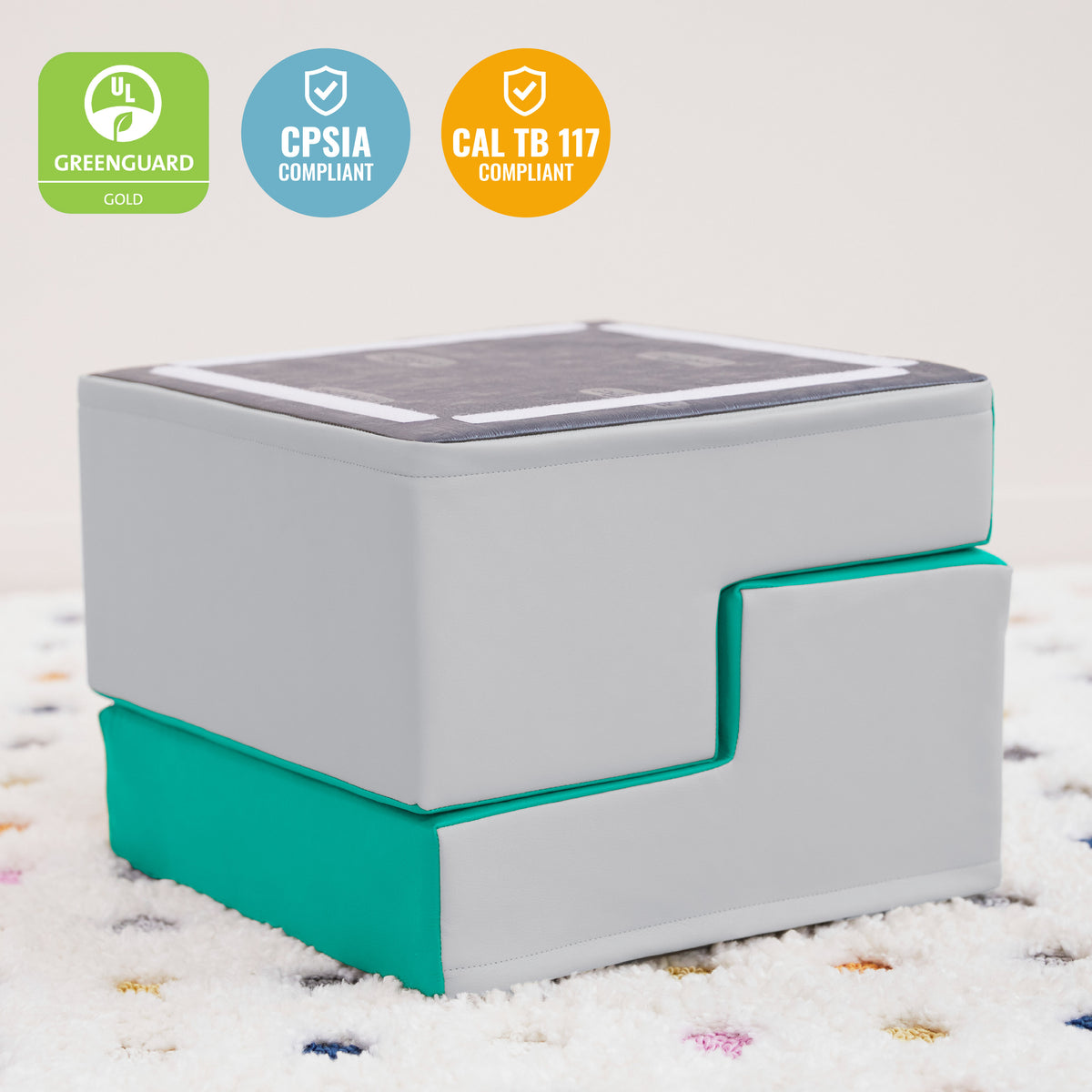 Gray and teal step stool with textured top surface and stacked storage compartments for children.