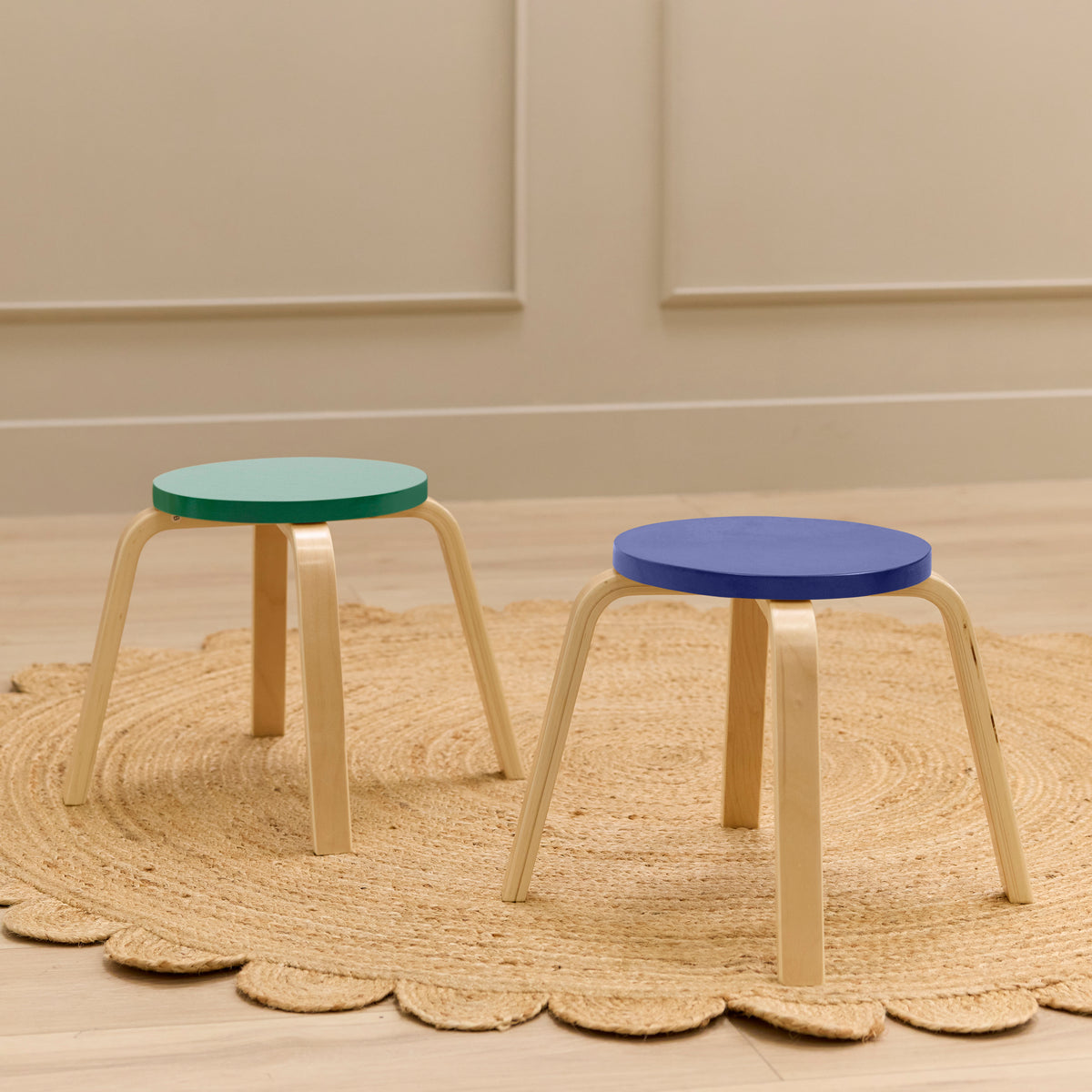 Two bentwood stools with curved wooden legs and round colored seats in green and blue.
