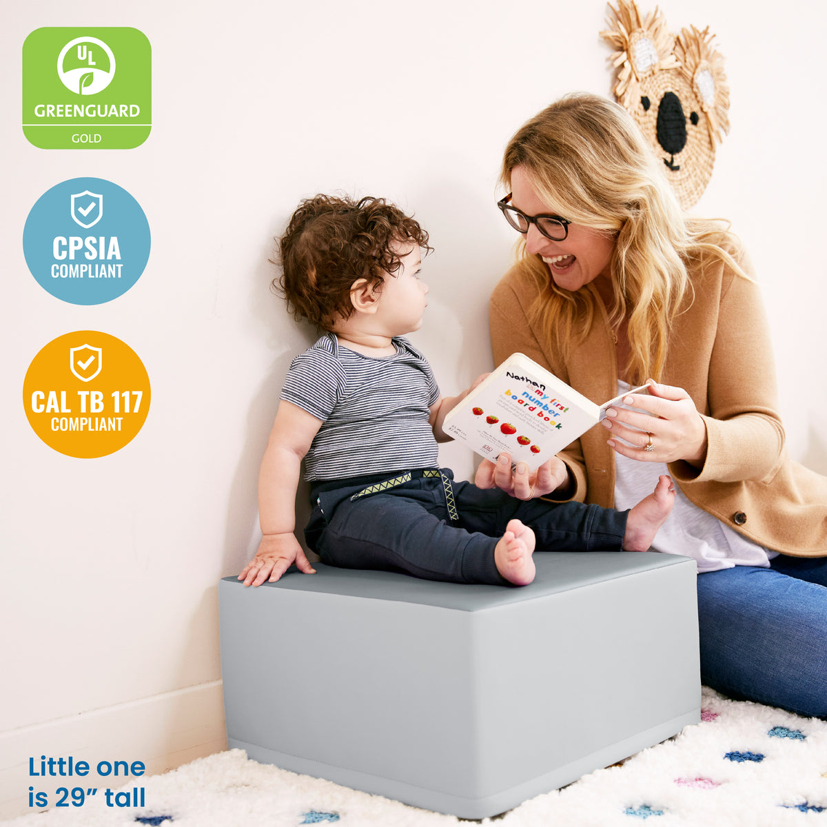 Modular climbing structure with turquoise and gray foam pieces arranged on speckled play mat.