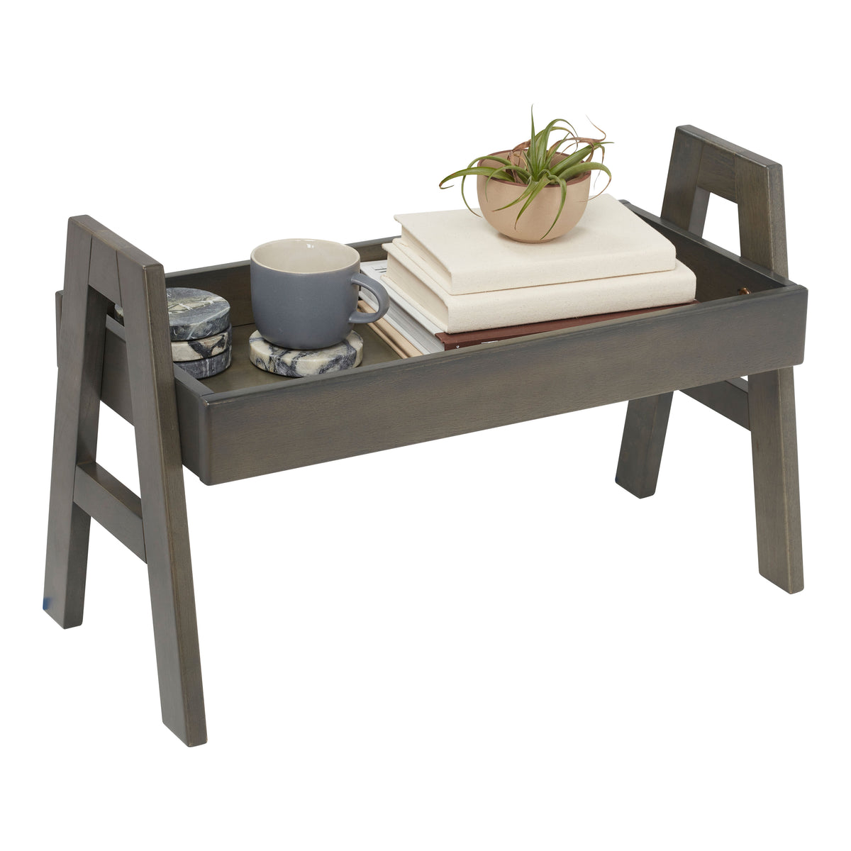 Gray wooden shelf organizer with handles holding books, potted plant, mug, and decorative items.